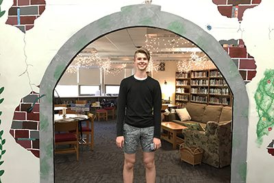 Student in front of arched doorway