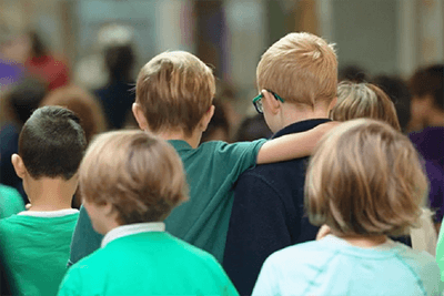 Two students leaving the CHAMP assembly with an arm around the other